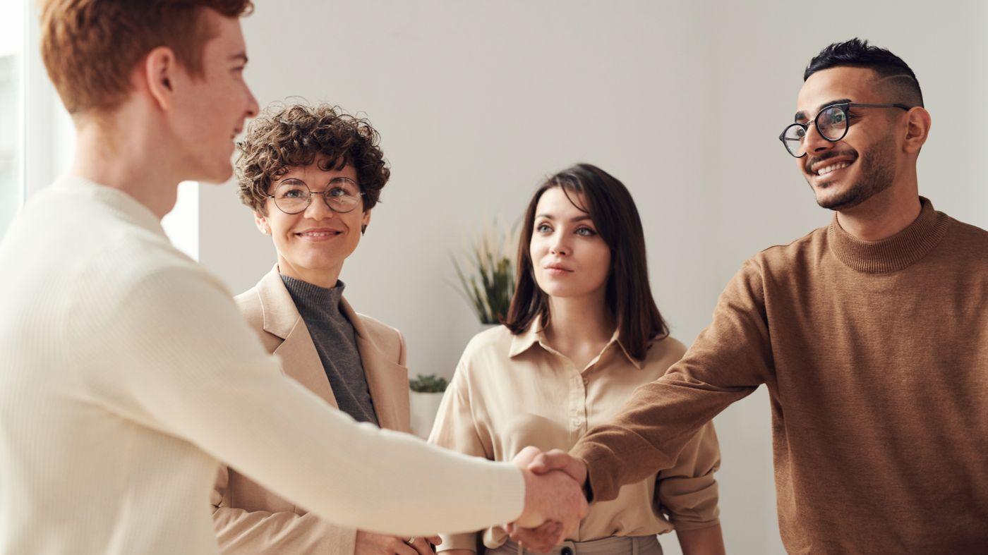 Smiling colleagues shaking hands