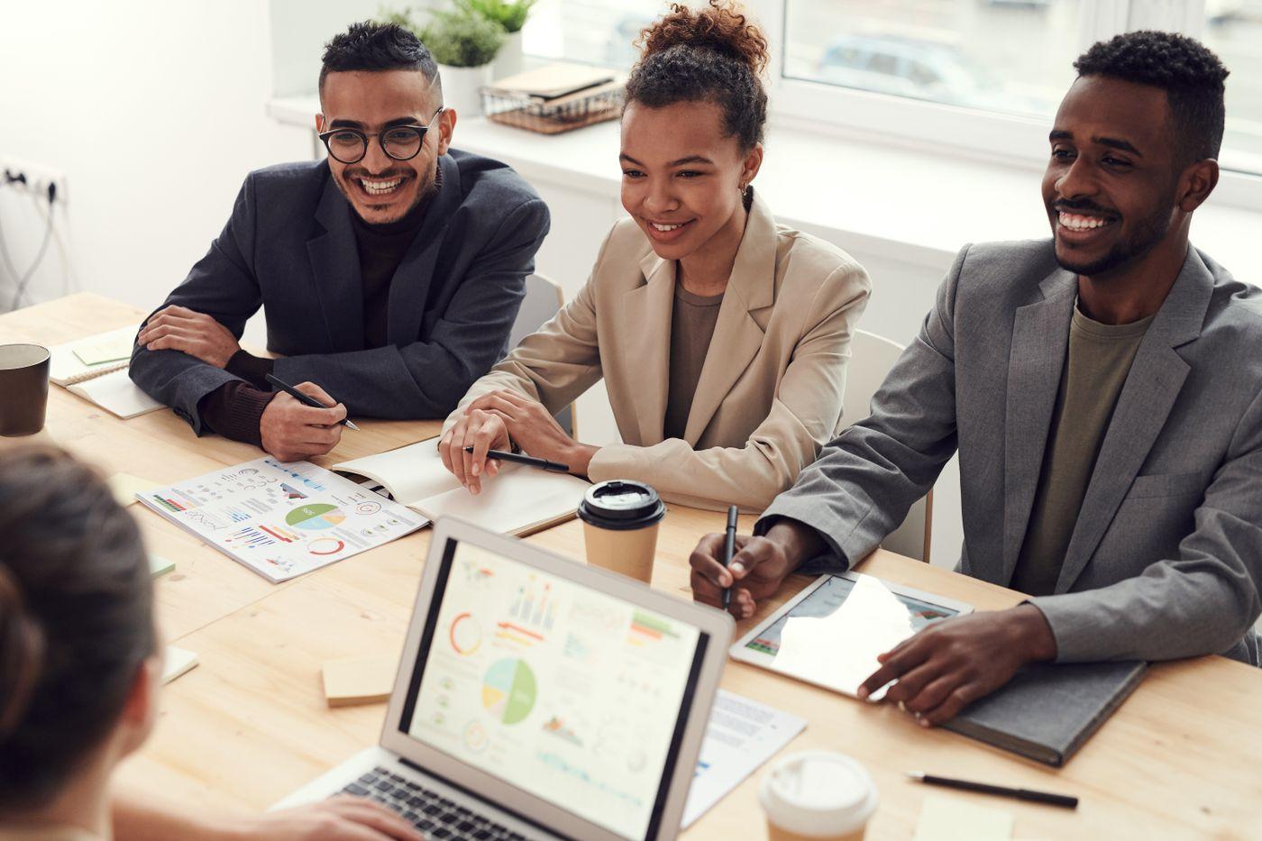 Smiling business professionals reviewing financial plans together